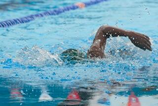 A swimmer cutting through clear blue pool water